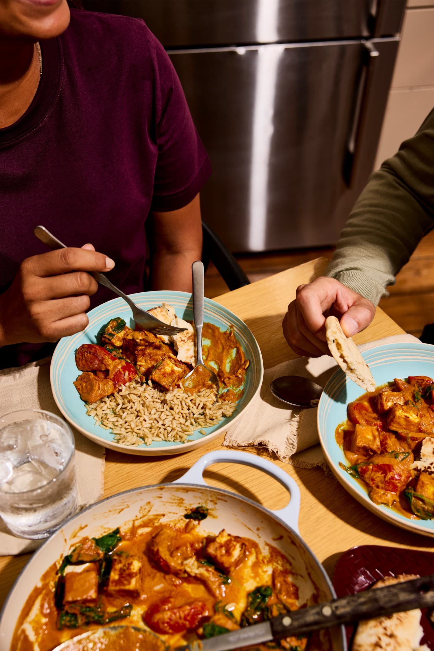 Chilli paneer masala with rice and naan being shared over dinner