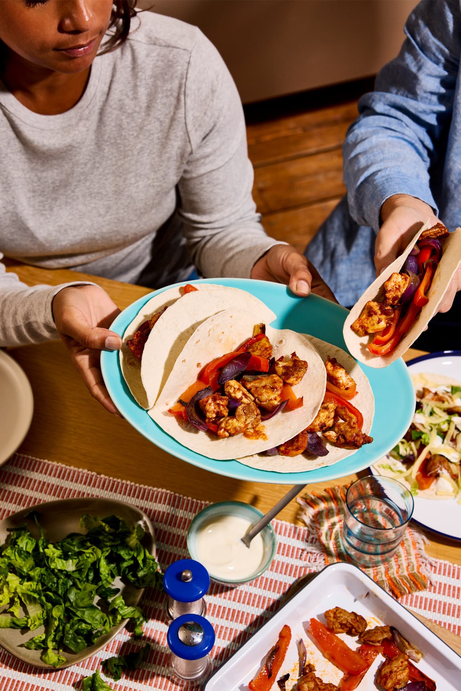 Sharing smoky chicken and pepper fajitas at the dinner table